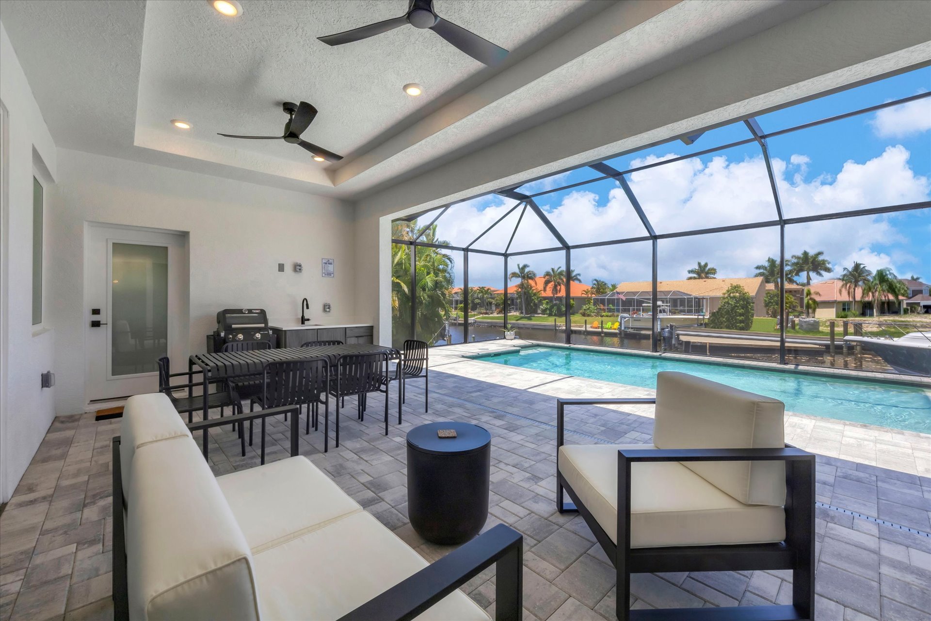 The best of Florida outdoor living. Lanai with outdoor kitchen overlooking the sparkling private pool and canal