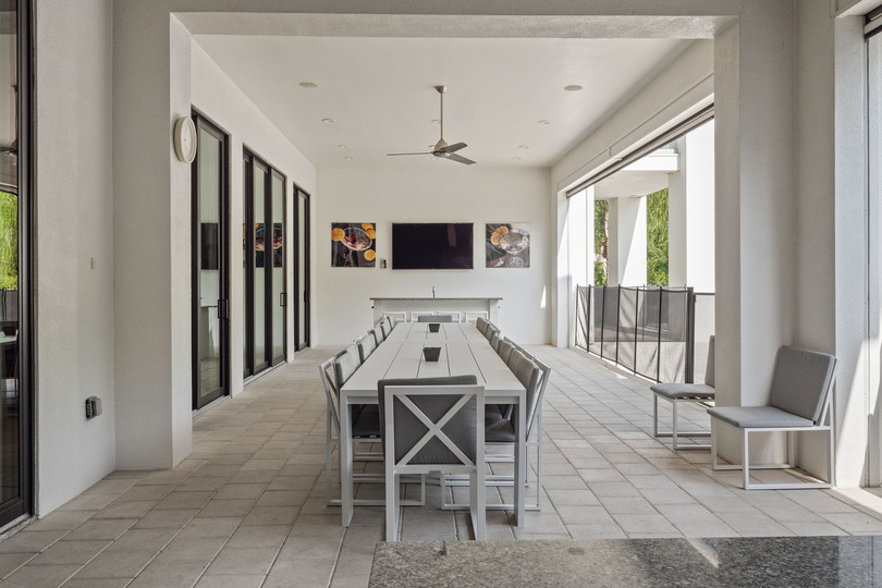 Dine al fresco under the covered lanai. The pool safety fence provides an added layer of protection
