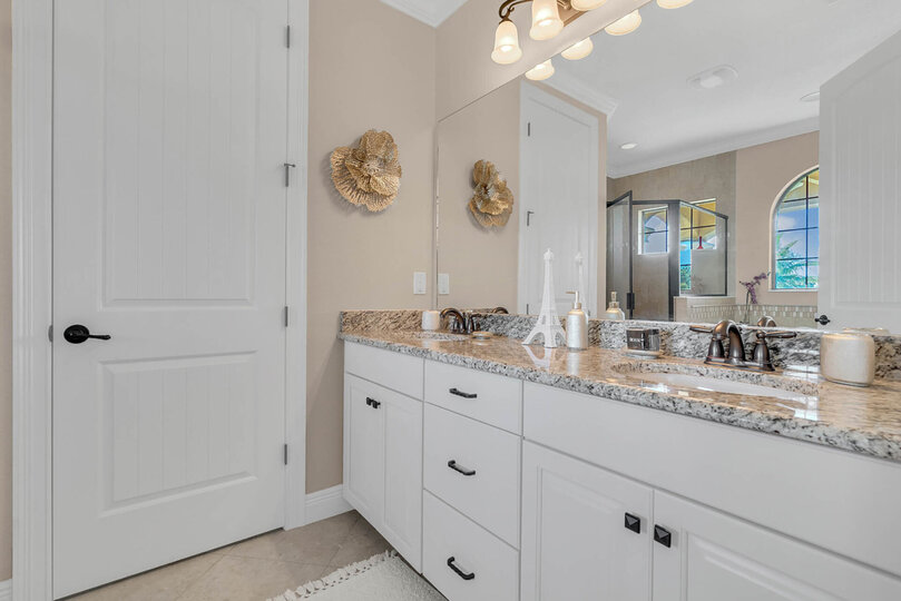 The lavish ensuite master bathroom continues the Parisian theme