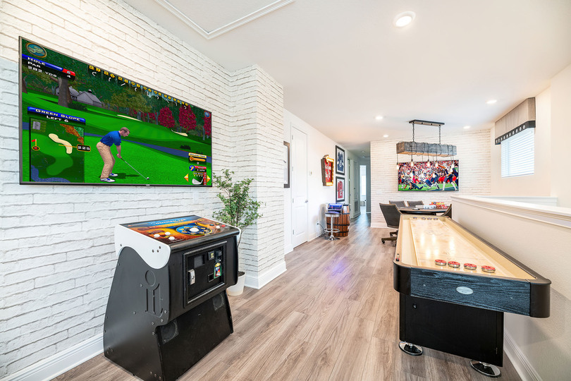 The entertainment loft offers Golden Tee Live, shuffleboard, Pac-Man, a professional poker table, and a wall-mounted Smart TV