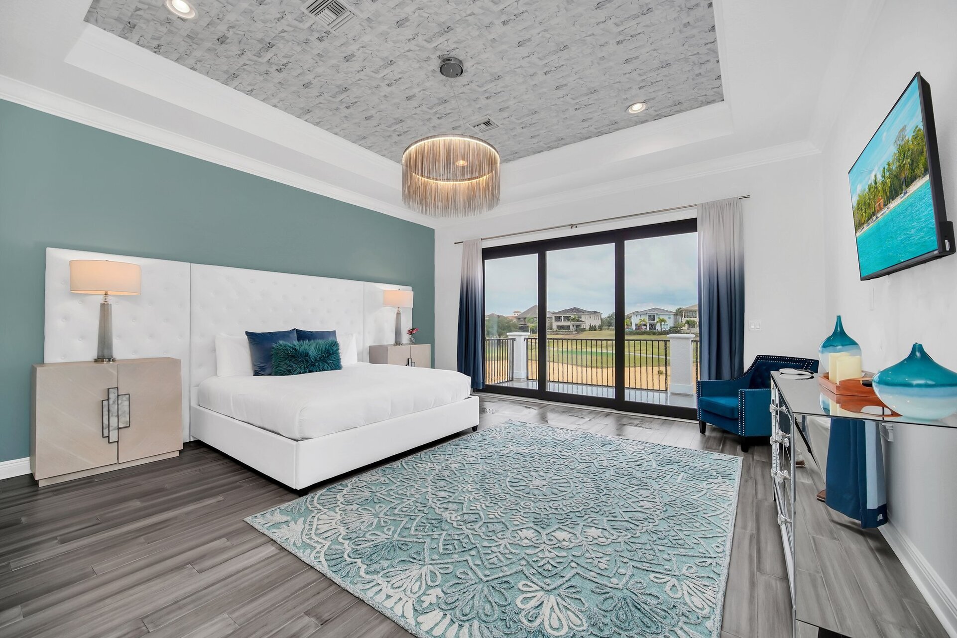 Master bedroom on the second floor, boasting a grand King bed, expansive windows flooding the space with natural light.