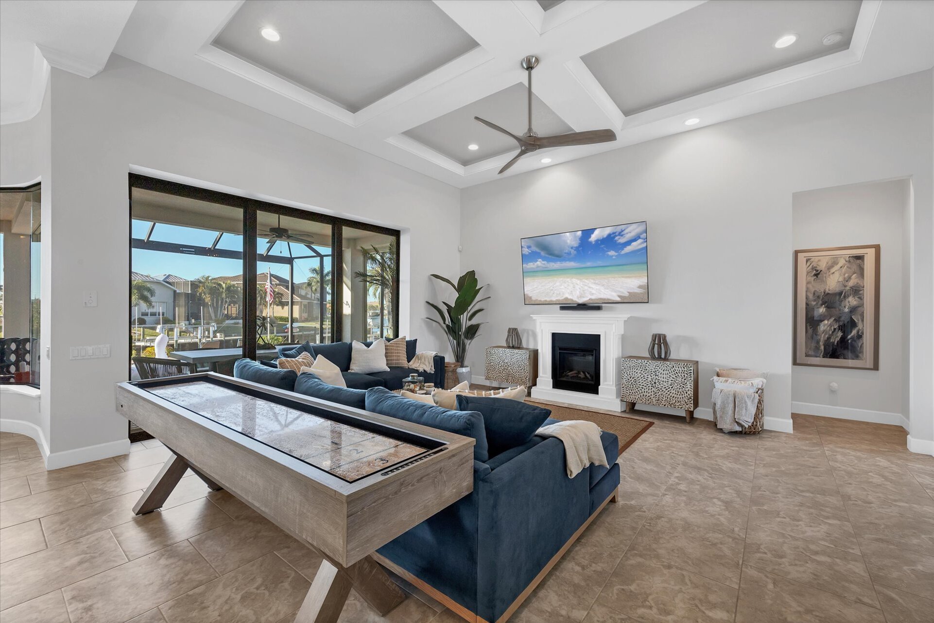 Beautiful, bright, open living space. Living room features ample seating, shuffleboard table, electric fireplace, lanai access, and huge 84-inch Smart TV